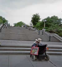 photo Jum Derksen in wheelchair at base of stairs
